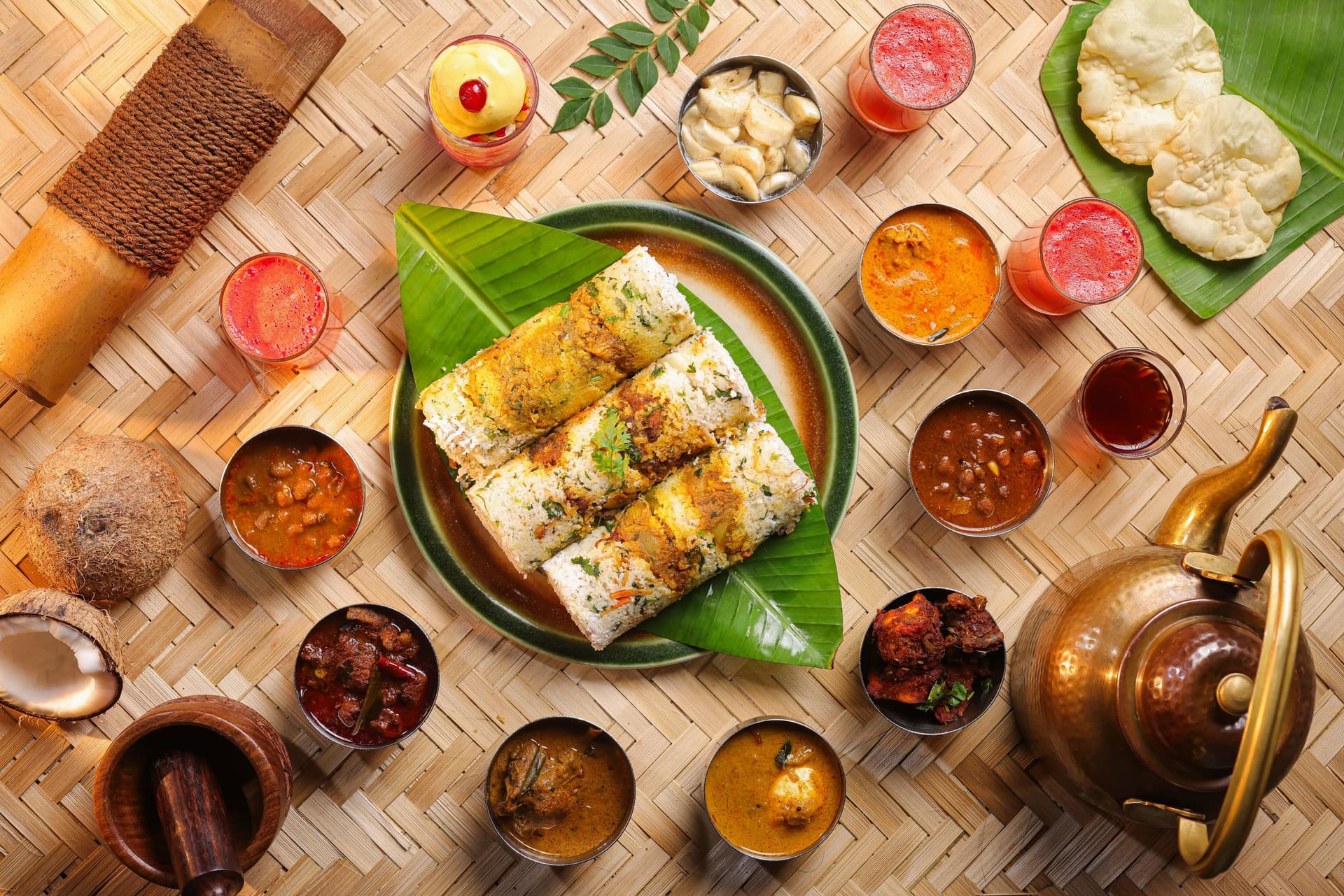 Puttu rolls on a banana leaf, laid out overhead and ringed by curries, chutneys and a brass kettle