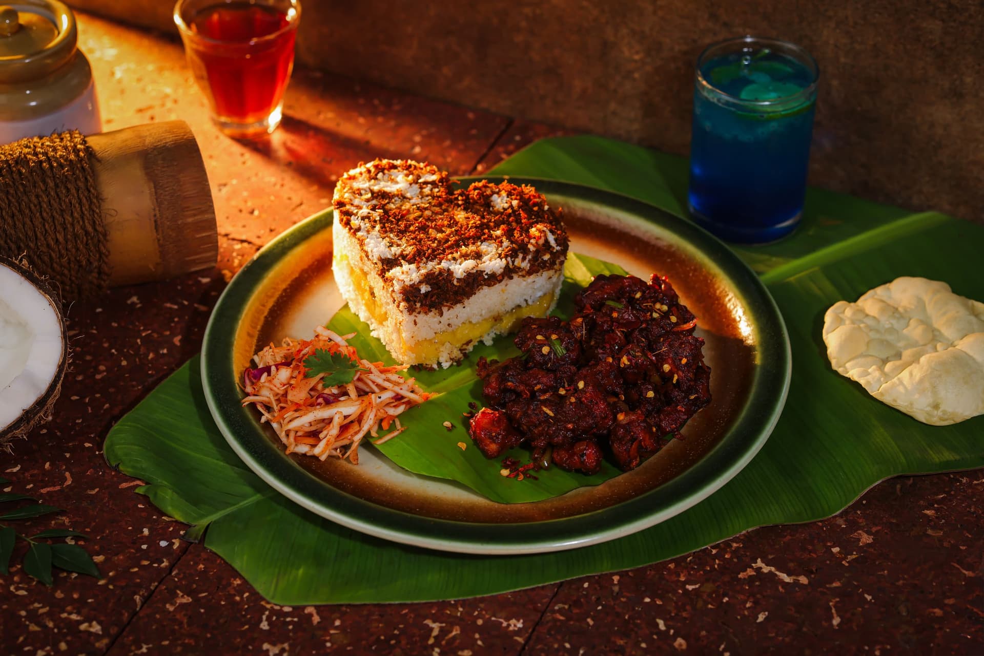 Marble puttu, a heart-shaped swirl of chocolate and vanilla, beside beef fry on a banana leaf